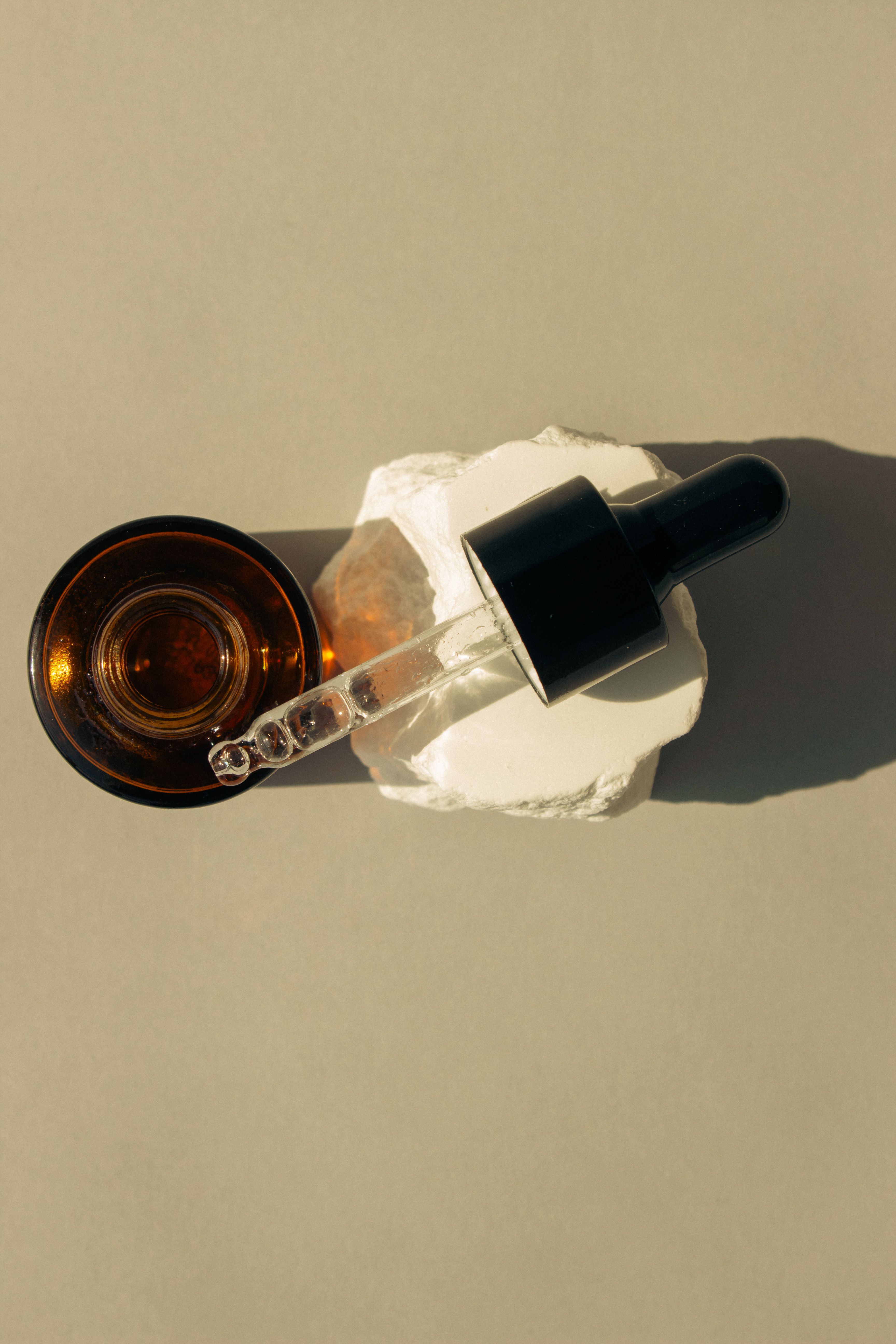 Niacinamide serum in an amber dropper bottle resting on stone